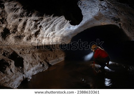 Cave explorer, spelunker, archeologist stuydying underground passage in a cave