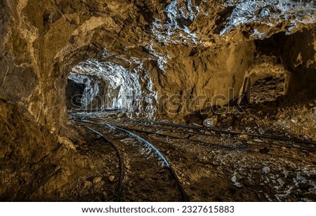 In the cave of the old tunnel. Mineshaft cave. Cave in mines. Rails in mineshaft cave