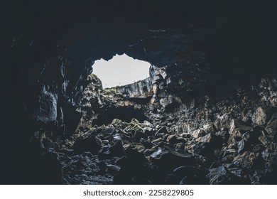 Cave with opening and light coming through. Walking through lava cave in Iceland - Shutterstock ID 2258229805
