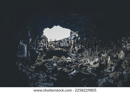 Cave with opening and light coming through. Walking through lava cave in Iceland