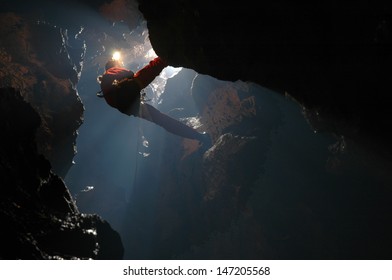 Caver abseiling in a pothole