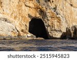 Caves in cliffs along the Mirador coastline, Image shows a sea cave carved into Spanish cliffs from a small boat 