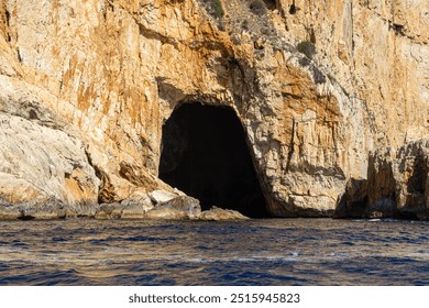 Caves in cliffs along the Mirador coastline, Image shows a sea cave carved into Spanish cliffs from a small boat  - Powered by Shutterstock