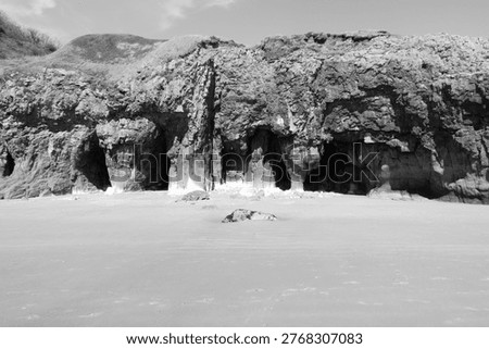 Caves in the rugged limestone cliffs at the sandy beach in Pendine, Carmarthenshire, Wales, UK.