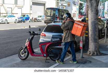 Caviar Delivery Person Prepares To Ride Electric Scooter By Scoot Rides To Deliver Food To Customers. Caviar Is A Food Ordering Service Owned By Square - San Francisco, California, USA - July 12, 2019