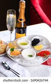 Caviar, Sterlet Caviar, Pike Caviar On White Plate With Ice. Croutons. Bottle And Glass Of Champagne. Sparkling Wine