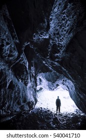 Caving Adventure. Man At Cave Entrance Exploring The Dark Underground Tunnel