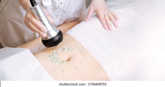 The cavitation procedure closeup. Beautician apparatus for cavitation on the woman's stomach. The concept of skin care face and body