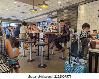 CAVITE, PHILIPPINES - MAY 3, 2022: A Family Is Dining Inside A McDonald's Restaurant In The Philippines.