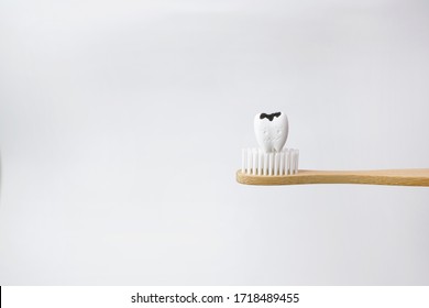 Cavity Decayed Tooth On Wooden Brown Toothbrush On White Background, How To Prevent Tooth Decay And Cavities