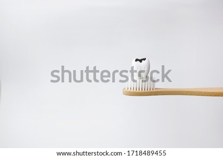 Cavity decayed tooth on wooden brown toothbrush on white background, How to prevent tooth decay and cavities