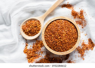 The Cayenne Pepper In A Wooden Cup Is Placed On A White Cloth.