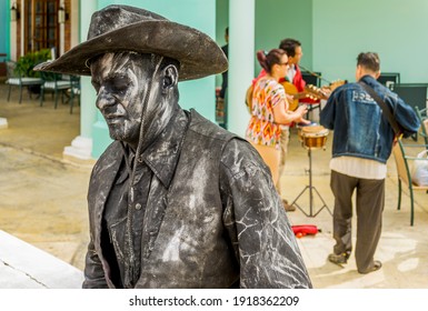 Cayo Santa Maria, Cuba, February 2016 - Close view of the bust of a street mime in cowboy outfit with musical performers in the background