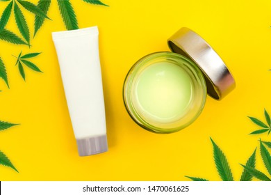 CBD Cannabis Balm And Lotion With Cannabis Leafs On Yellow Background