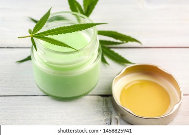 CBD Cannabis Hemp Topical Cream Balm With Cannabis Leafs On Wooden Table