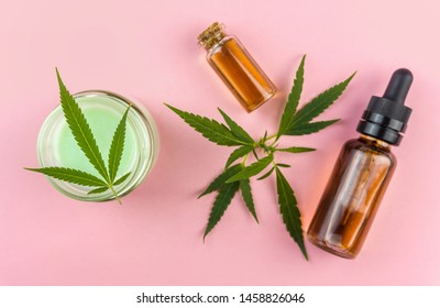 CBD Cannabis Hemp topical cream and oils balm with cannabis leafs on pink backdrop