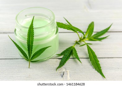 CBD Cannabis Hemp topical cream balm with cannabis leafs on wooden table
