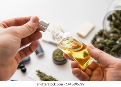 CBD Cannabis OIL On White Background, Close Up, Bottle Of Oil Cannabis In Pipette In Hand, Hemp Product, Medical Marijuana Concept,
