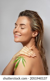 CBD Cosmetics Concept. Beautiful Woman With A Cannabis Leaf On Gray Background