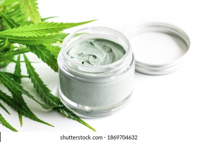 CBD Cosmetics. Green Cannabis Plant And Jar With A Moisturizing Rejuvenation Cream.