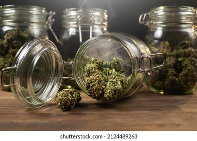 CBD hemp weed buds stored in a glass jar shrouded with a smoke cloud. Medical cannabis.