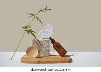 CBD Oil In Brown Bottle With Dropper And Cannabis Branch, Hemp On Podium Beige Background