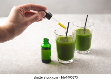 CBD oil dropper bottle and cannabis infused green health drink beverage for medical use. Cannabis drink infused with Indica sativa hybrid. Get well soon pain relief and nutrition.