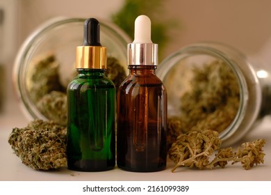 CBD oil on background with dry cannabis buds. Marihuana extract.