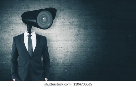 CCTV camera headed businessman standing on dark concrete background with copy space. Supervision and guard concept - Shutterstock ID 1104705065