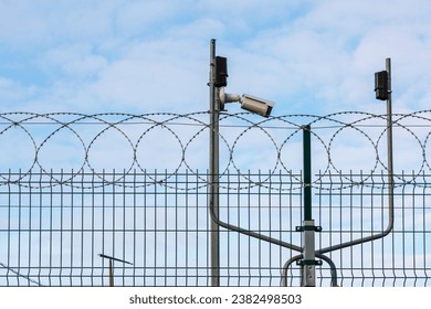 CCTV camera, motion sensors and spiral protective barrier. Facility security complex. - Shutterstock ID 2382498503