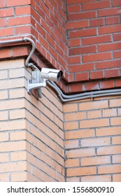CCTV camera mounted on red brick wall of building