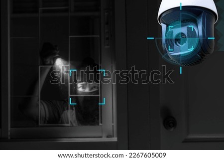 CCTV Camera Showing A Burglar Stealing Things In The House.Smart home security camera on the wall.Cameras work day and night,video recording in the dark.Protection from thieves and vandals.