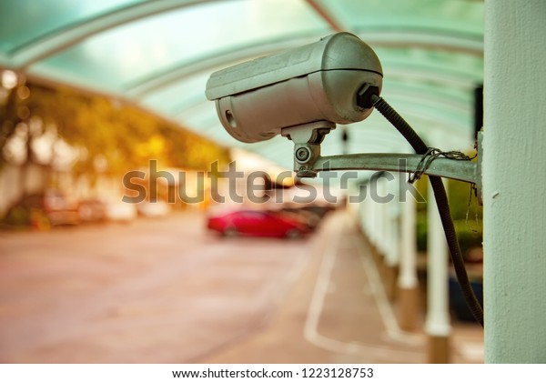 CCTV\
cameras are installed with poles in the parking lot. Security CCTV\
camera or surveillance system on the white\
wall.