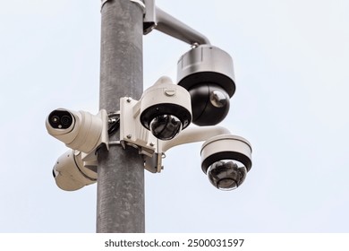 CCTV Cameras in Public Place. Surveillance Video Camera on Pole on Sky Background. Different Types of CCTV Camera Systems. Close up.  - Powered by Shutterstock