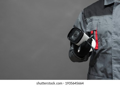 CCTV Installation specialist concept. Service for installing CCTV cameras. Security cameras in the service engineer hand close up on gray background with copy space.