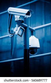 CCTV security camera against building in blue tone.
