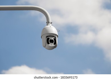 CCTV security cameras on a large post, taken on a sunny bright day with white clouds in the sky - Shutterstock ID 1833695173