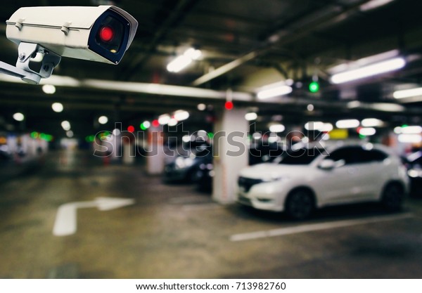 CCTV, security indoor camera system operating\
with blurred image of under ground indoor car parking garage area,\
RFID solution management system, surveillance security and safety\
technology concept