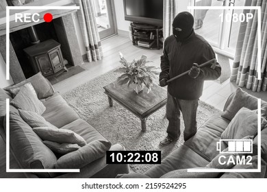 CCTV surveillance security camera of burglar breaking into home via back door window with crowbar house robbery concept - Shutterstock ID 2159524295