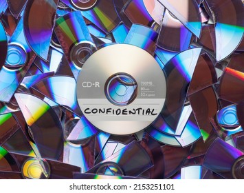 CD with confidential written on it, with shredded CD's and DVD's in the background.