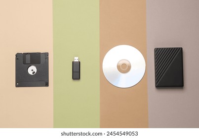 CD disk with floppy disk, USB flash drive and external hard drive on colored background. Digital information media. Flat lay