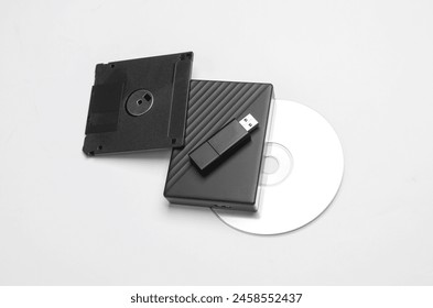 CD disk with floppy disk, USB flash drive and external hard drive on a white background. Digital information media.