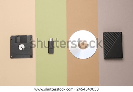 CD disk with floppy disk, USB flash drive and external hard drive on colored background. Digital information media. Flat lay