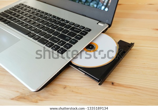 CD DVD Drive Writer Burner Reader\
internal of laptop computer on wooden\
background