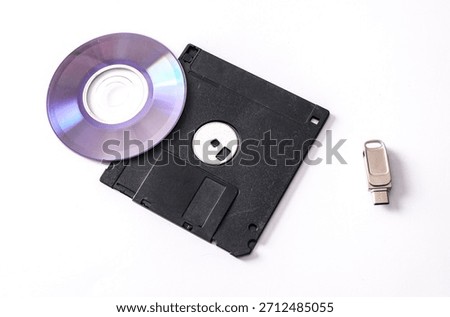 CD, floppy disk, and flash drive on a white background. The evolution of storage media.