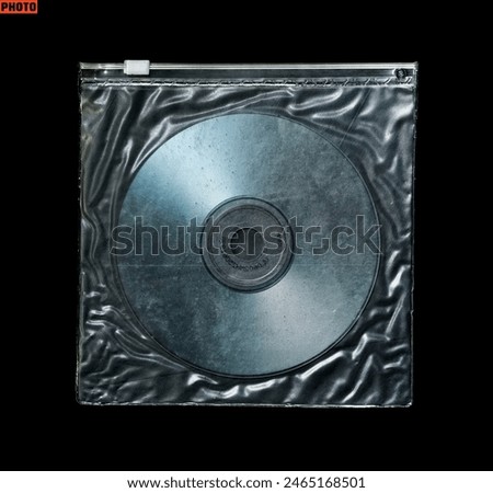 CD inside plastic bag with ziplock isolated on black background                       