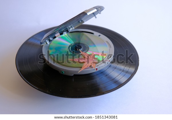  CD player. a fallen leaf lies on an old portable\
compact disc player