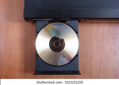 cd in retro cd player opened tray on brown table