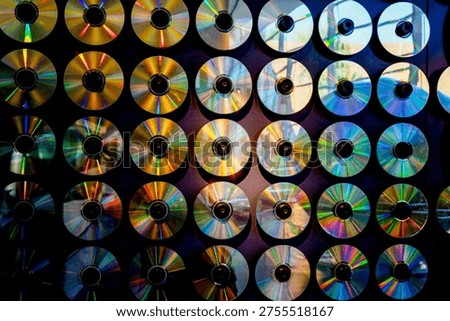 CDs and DVDs hanging on a wall with beautiful reflections of the light spectrum