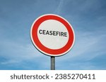 Ceasefire and cease fire - stoppage, halt and suspension of war and warfare. Temporary truce, armistice and peace between enemies. Road sign with text.